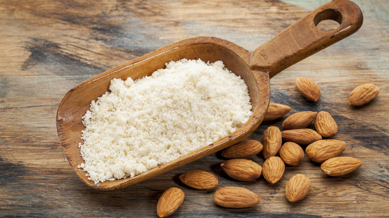 almond flour in a scoop against a brown background