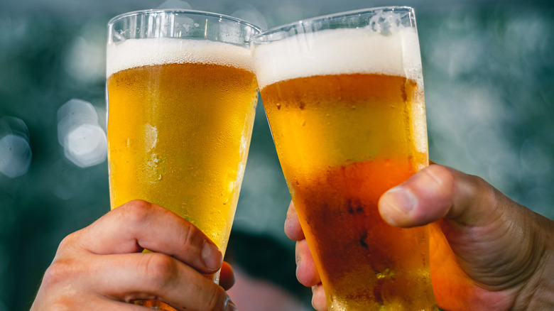People clinking IPAs in tall glasses