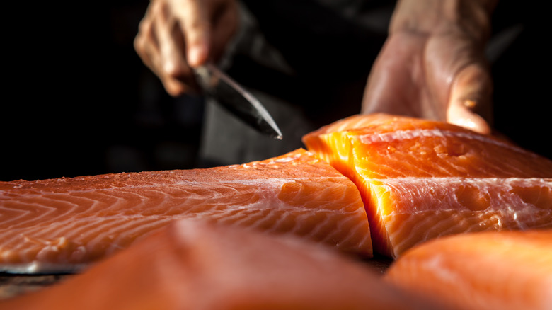 Person slicing salmon fillet