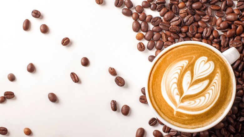 Latte surrounded by coffee beans