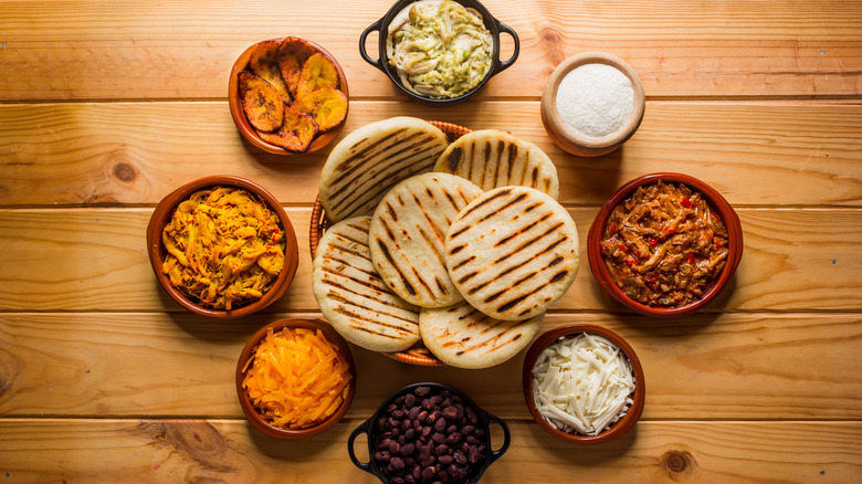 Bowl of arepas with ingredients surrounding it