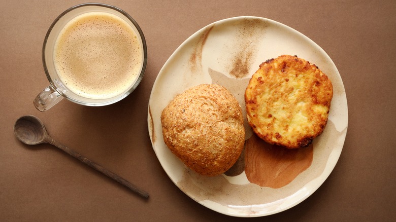 Arepa and bread on plate with a cup of coffee