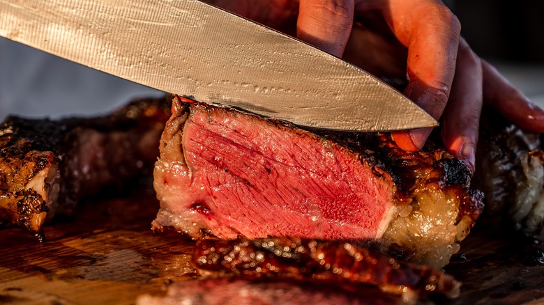 Cook cutting ribeye