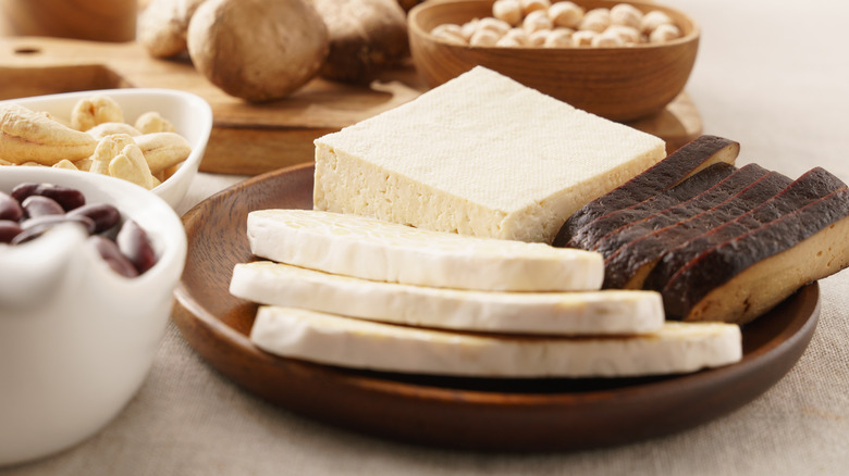 Sliced tofu and tempeh on a wooden plate
