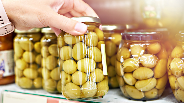 Woman buying jarred olives