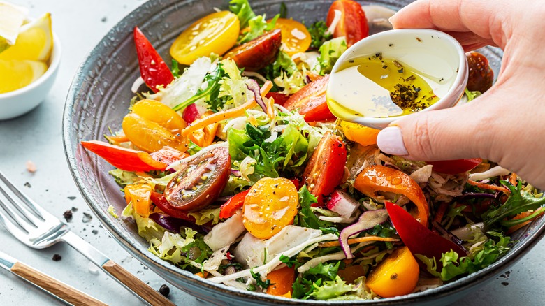 salad with dressing pouring in