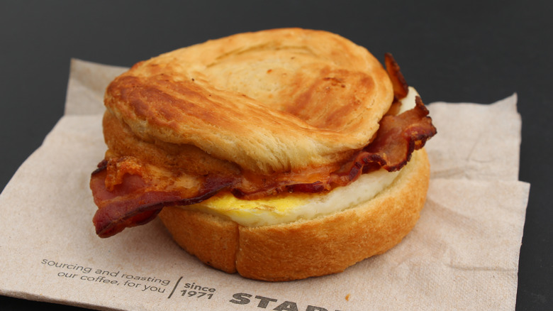 A bacon and egg sandwich over a Starbucks napkin 
