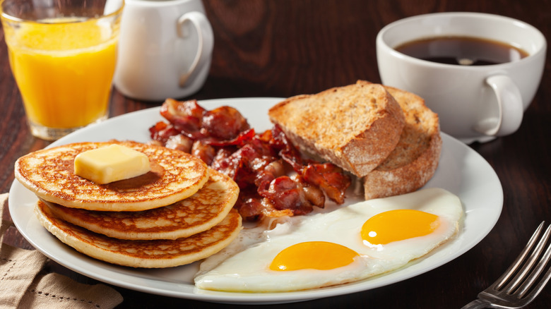 Pancakes, eggs, toast, bacon, coffee and juice