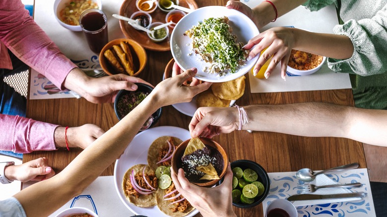 People sharing Mexican food table