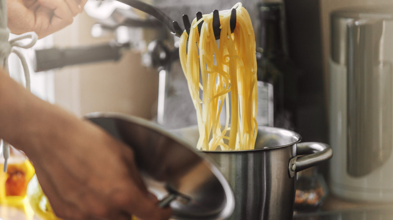 pulling spaghetti out of pot