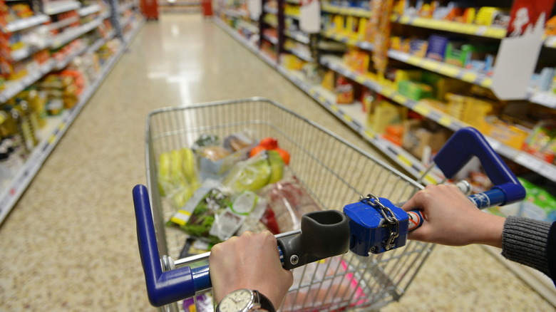 pushing Aldi cart in aisle