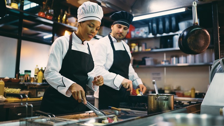 chefs with hats cooking in a kitchen