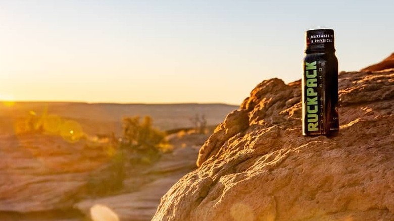 A bottle of RuckPack on a cliffside facing the sunrise