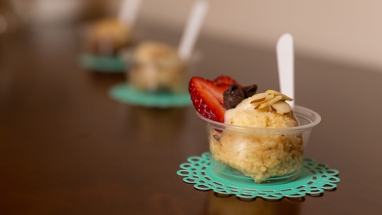 plastic bowl of bread pudding with strawberry and almonds