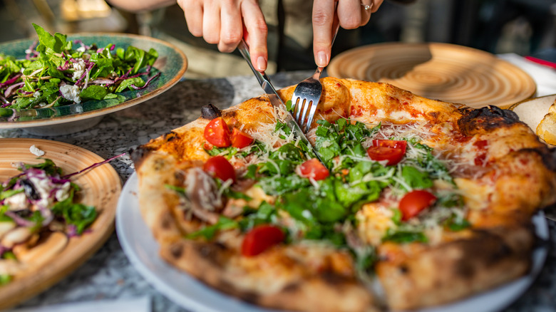 cutting pizza with fork