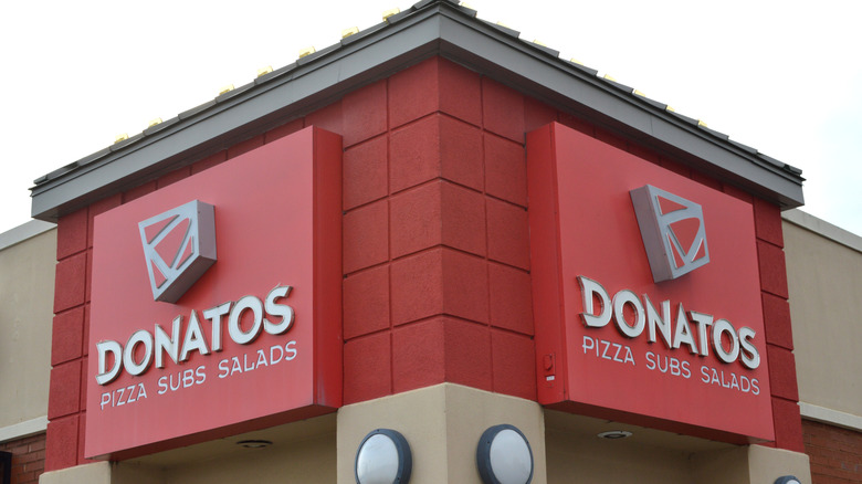 Two red Donatos signs on the corner of a building