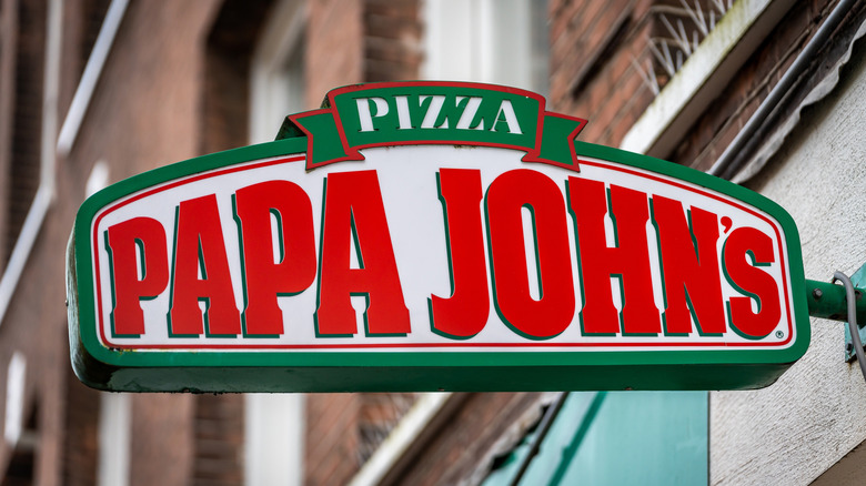 A neon-trimmed sign for Papa John's Pizza