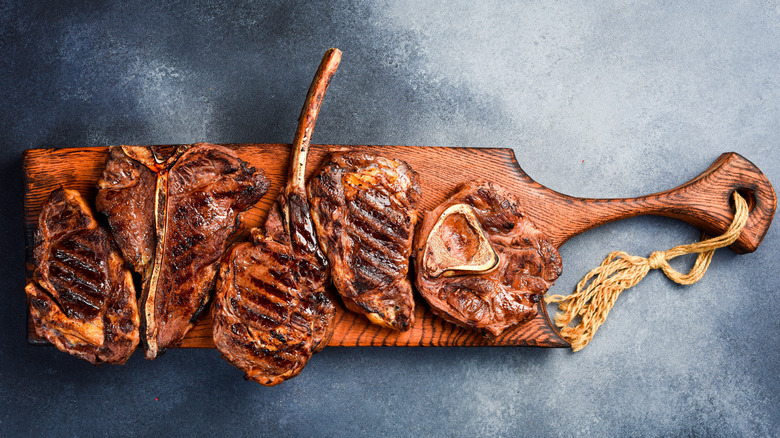 Variety of grilled steaks on wooden cutting board