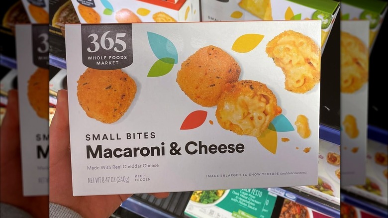 Hand holding a box of 365 Whole Foods Market Small Bites Macaroni & Cheese