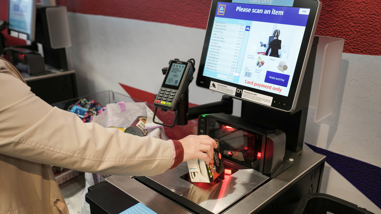 Person scanning groceries at an Aldi self-checkout