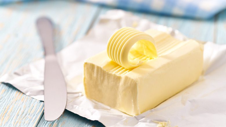 unwrapped butter stick and knife