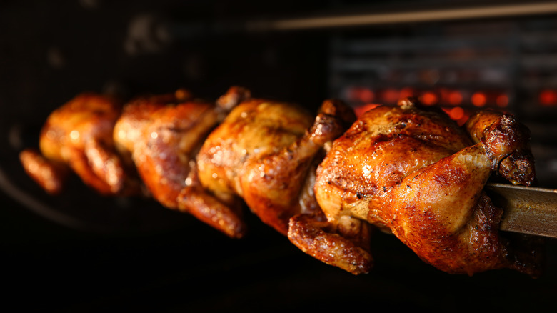Four chickens in rotisserie machine