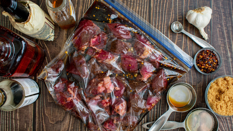 Uncooked beef tips marinated in a plastic bag.