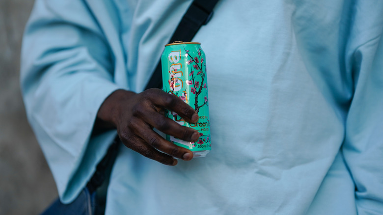 A man holds a can of AriZona green tea