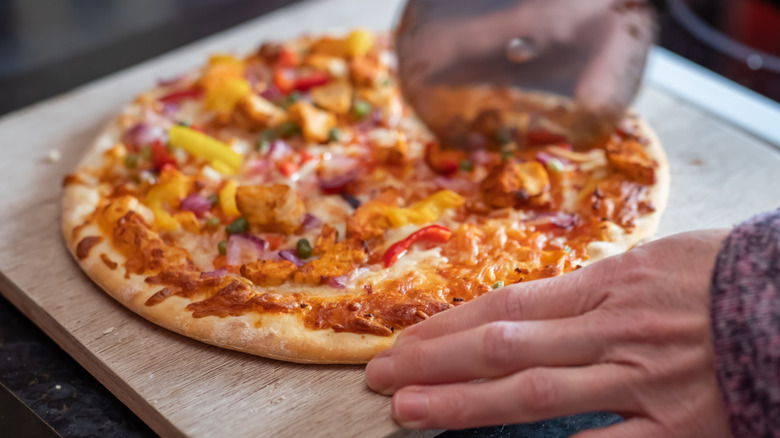 Person cutting a pizza