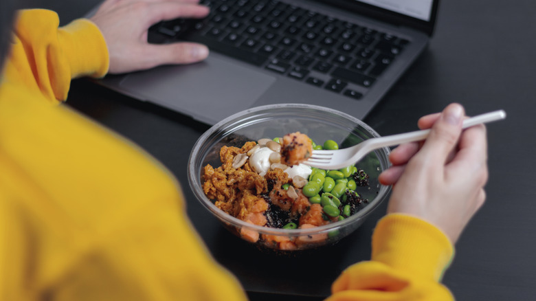 A person eating out of a plastic container