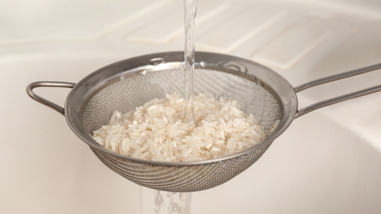 Rinsing rice in a strainer. 