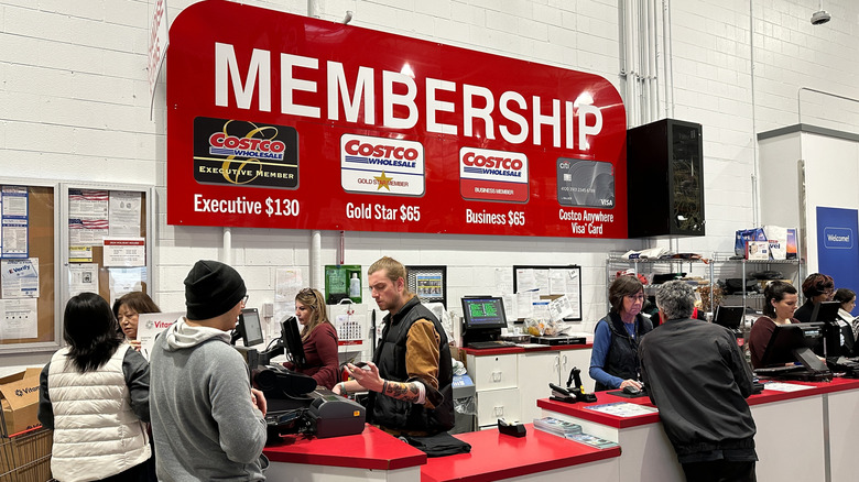 Costco employees helping customers at the membership counter