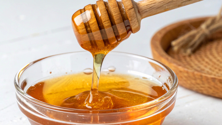 Close-up of honey in small glass bowl with dripper