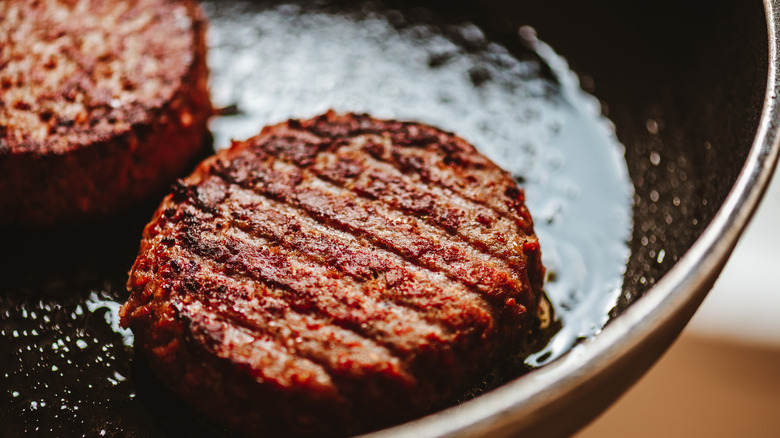 Burgers in oiled skillet