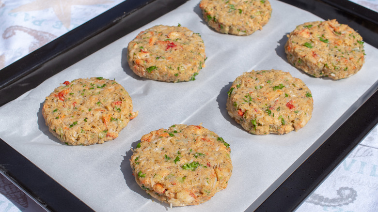 A tray of six uncooked crab cakes