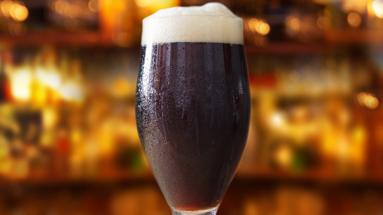 A tulip glass of dark-colored beer with a foamy head