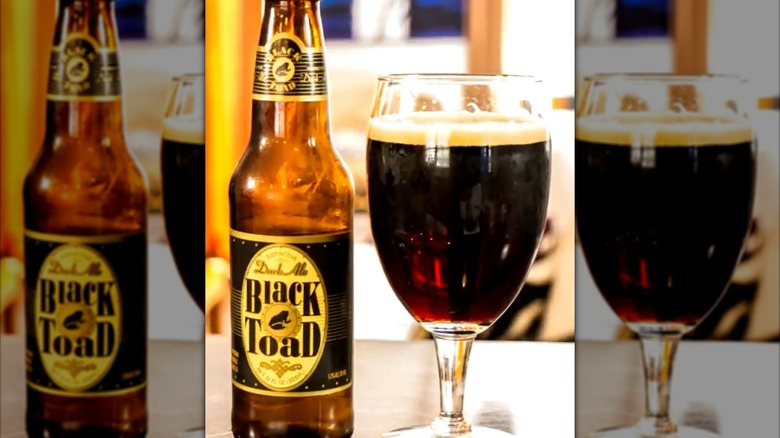A bottle of Trader Joe's Black Toad dark ale, next to a tulip glass full of the same beer