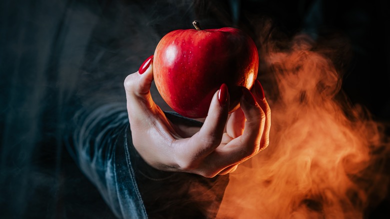 poison apple in curled fingers
