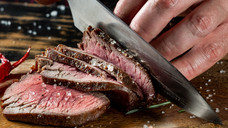 person chopping steak