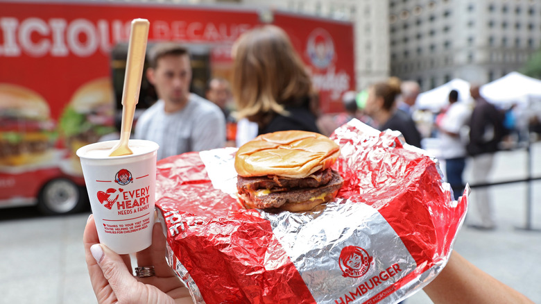 Baconator from Wendy's held in the air with frosty