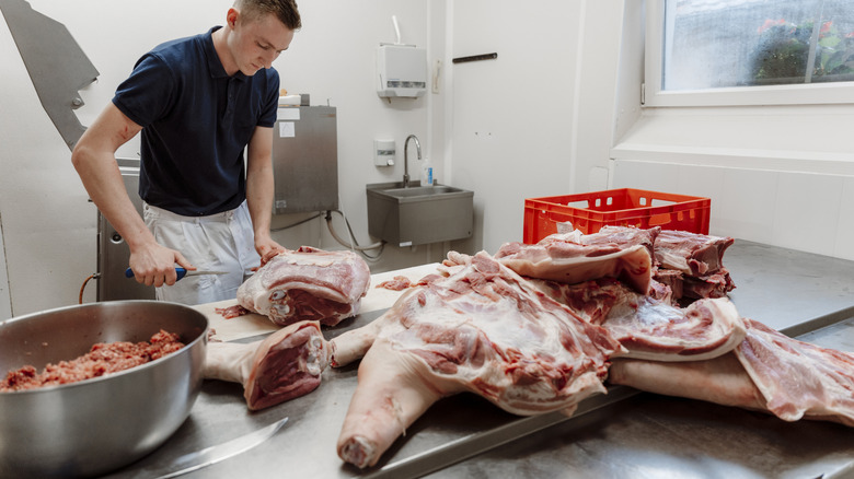 A man butchering large pieces of beef