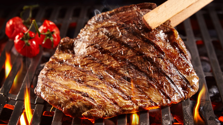 Searing steak on flaming grill