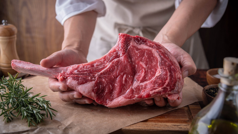 chef with raw lamb chop
