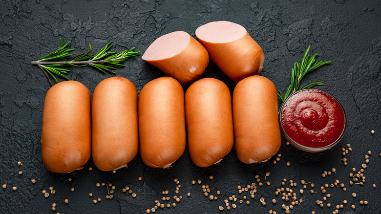 row of Vienna sausages ketchup black surface