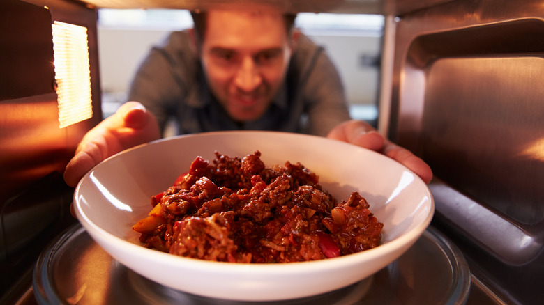 inside microwave view of man heating food