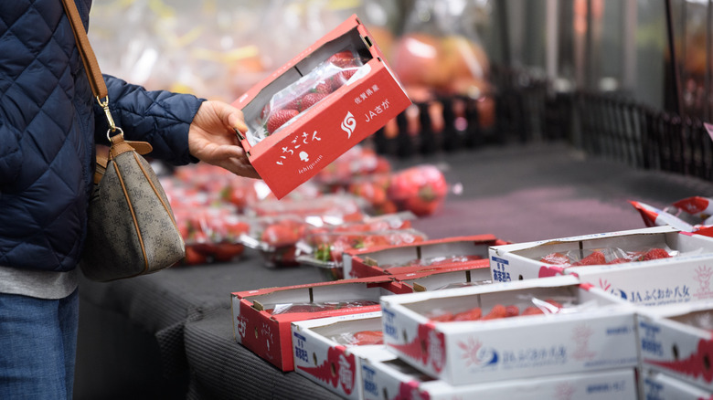 Choosing strawberries in store