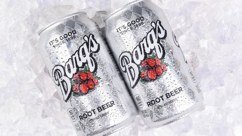 Two cans of root beer on ice