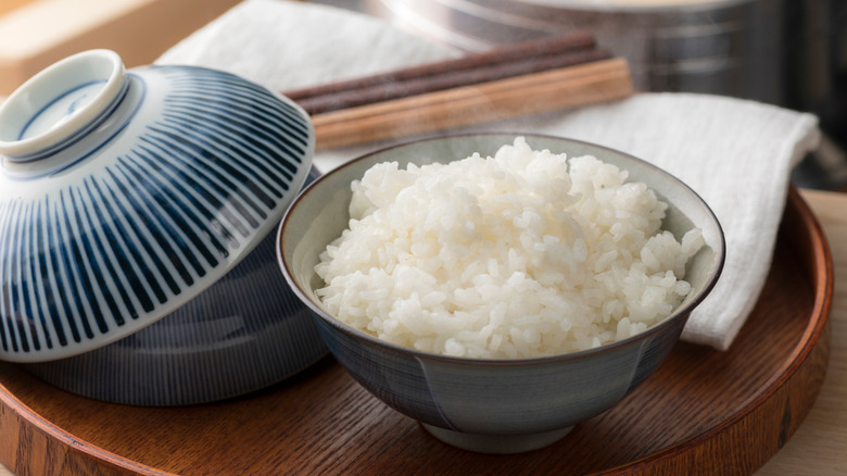 A steaming bowl of Japanese rice cooked in a traditional pot