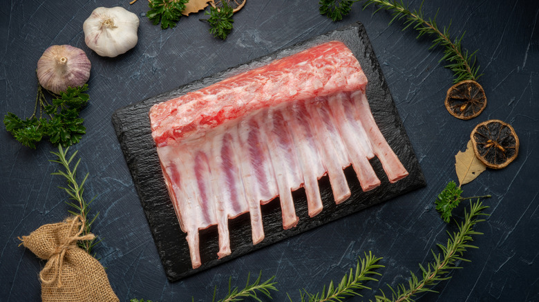 raw rack of lamb with garlic, herbs and aromatics