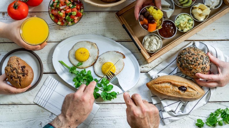 Hands around a plate of two plant-based sunny side up eggs